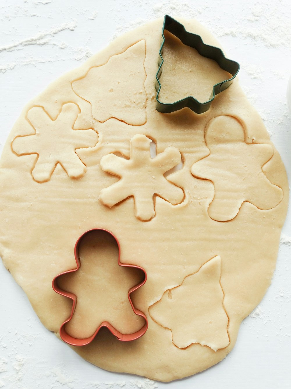 dough with Christmas tree and Snowman cookie cutters