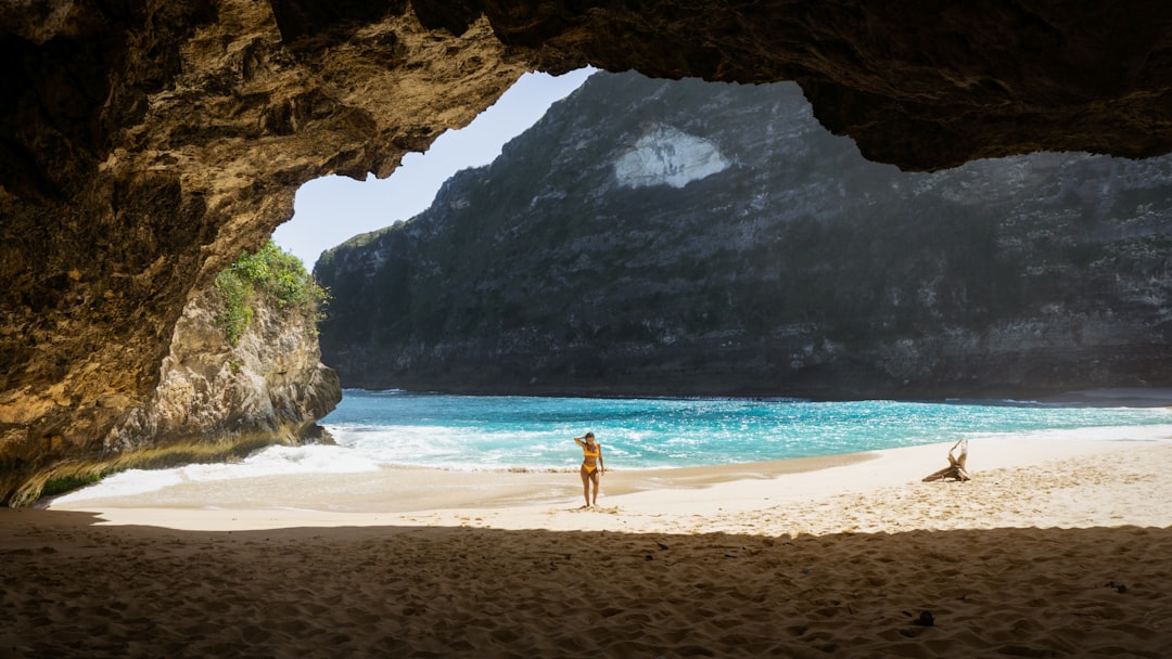 landscape photography of woman standing on seashore, A girl in a bikini standing on the beautiful Kelingking Beach Nusa 