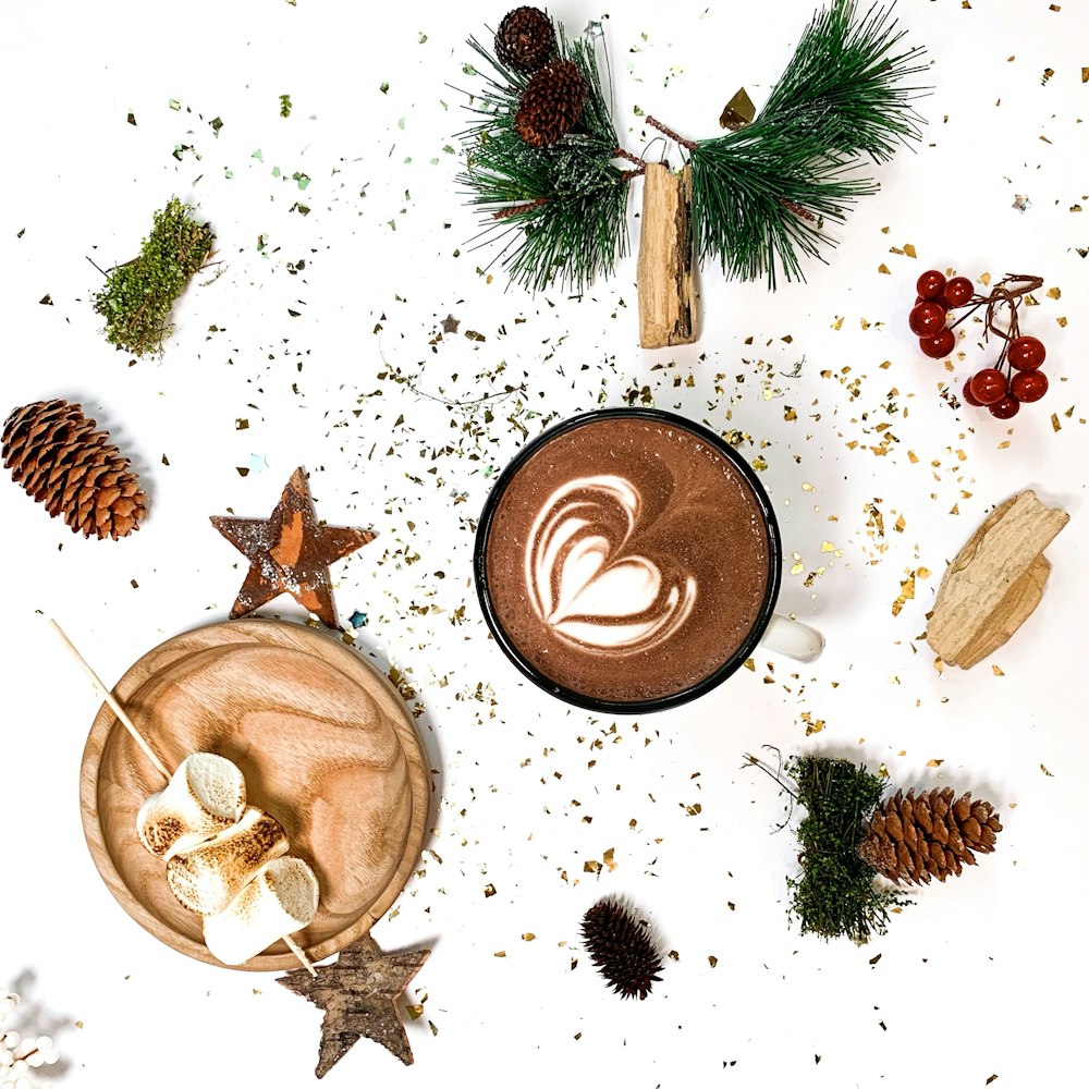 pine cone, star, and green leaves with cup of coffee