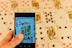 A joyful player holding a smartphone showing the 3patti game interface with colorful cards.