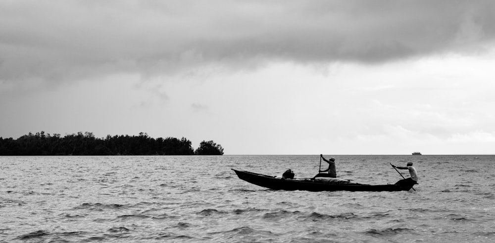 silhouette of men riding a boat