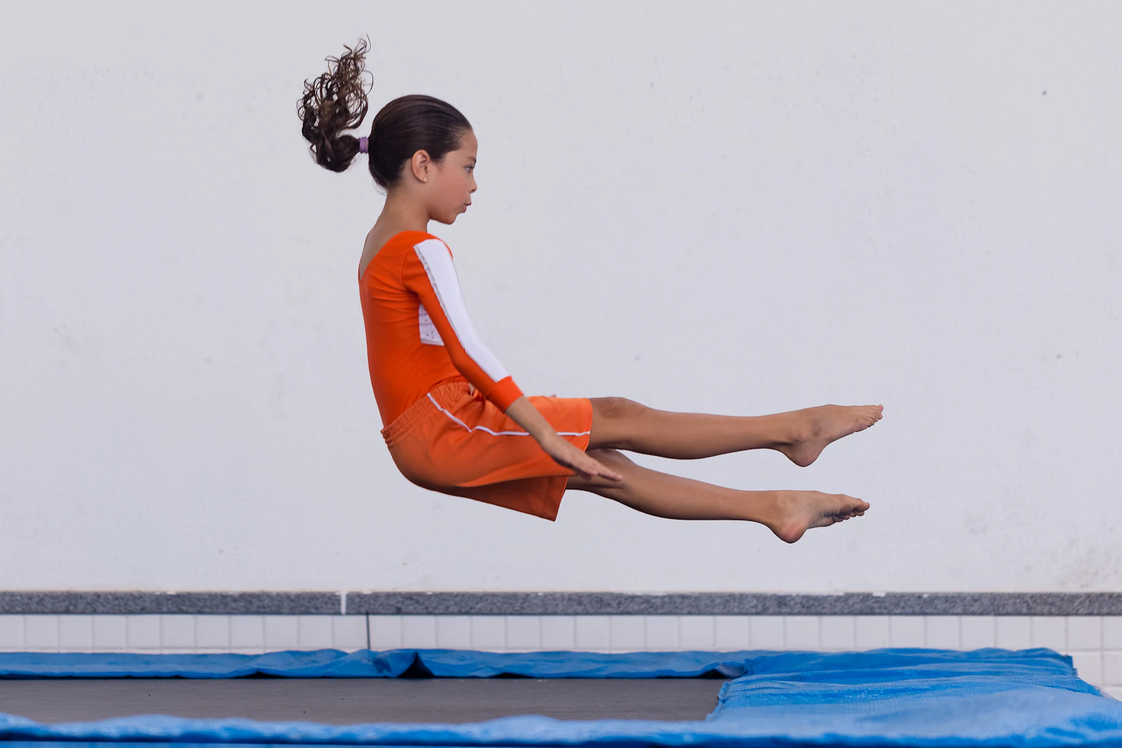 Niña en el aire sobre un trampolín