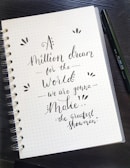 An open notebook with a pen, surrounded by motivational quotes.