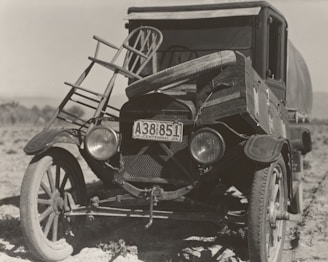 grayscale photography of vintage vehicle on road
