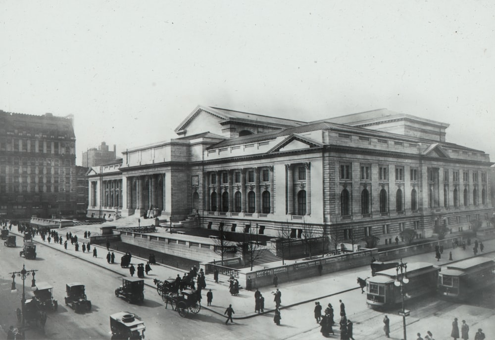 grayscale photography of people walking near historic building