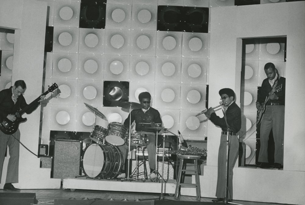 grayscale picture of four male performing band