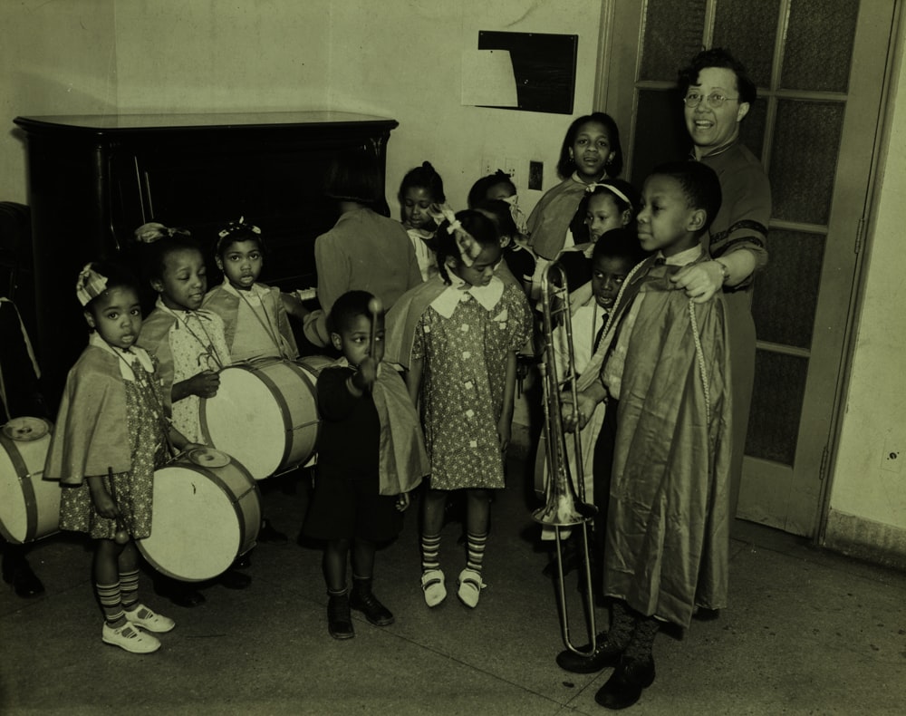 grayscale picture of a woman and group of children