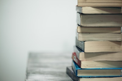Close-up of freshly printed books stacked neatly on a wooden table.