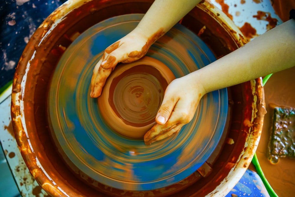 person making clay pot