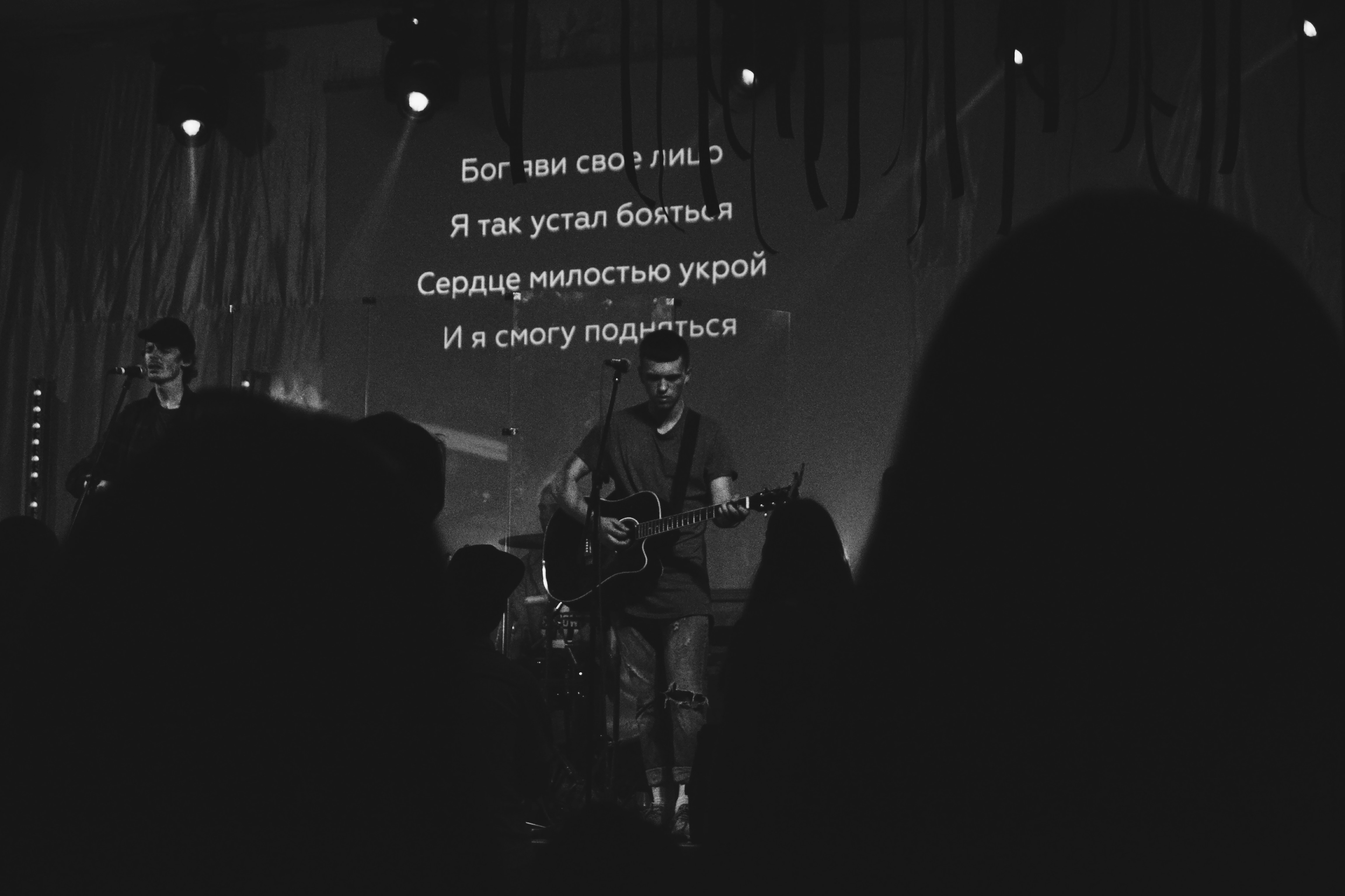 man playing guitar near people