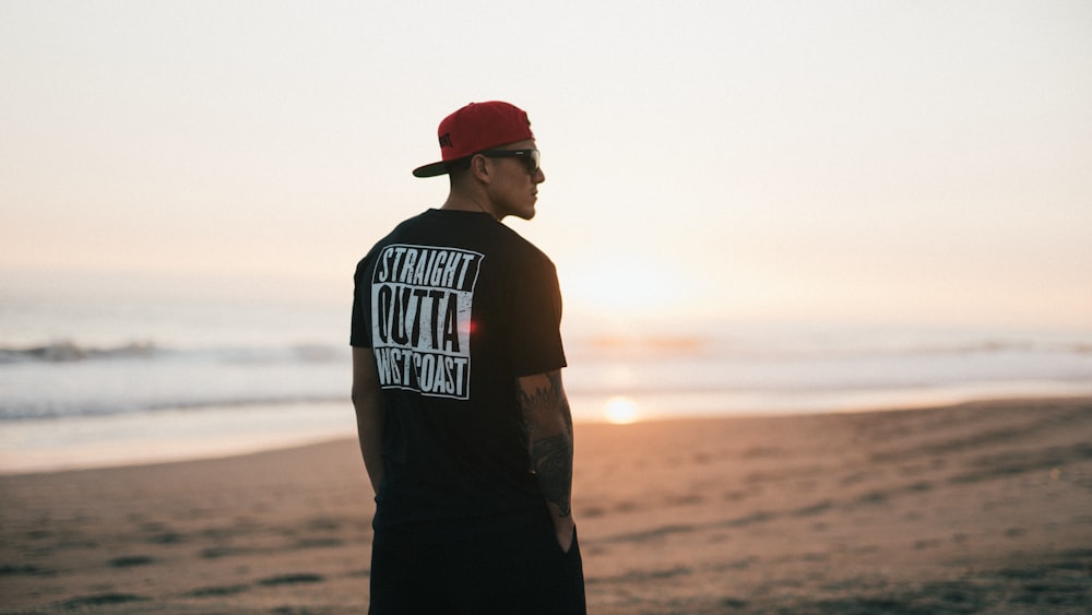 man standing and looking at his right on seashore during day