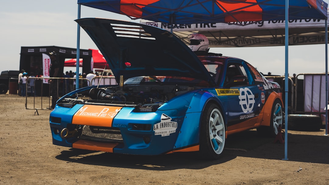 blue and orange race car parked under blue canopy