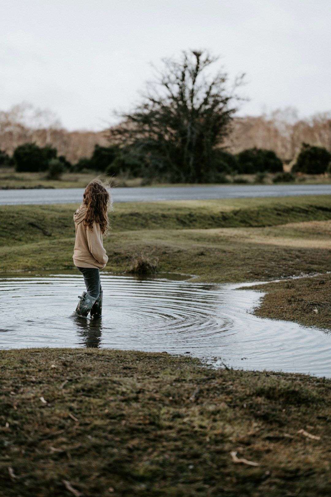 woman wearing hoodie standing on puddle