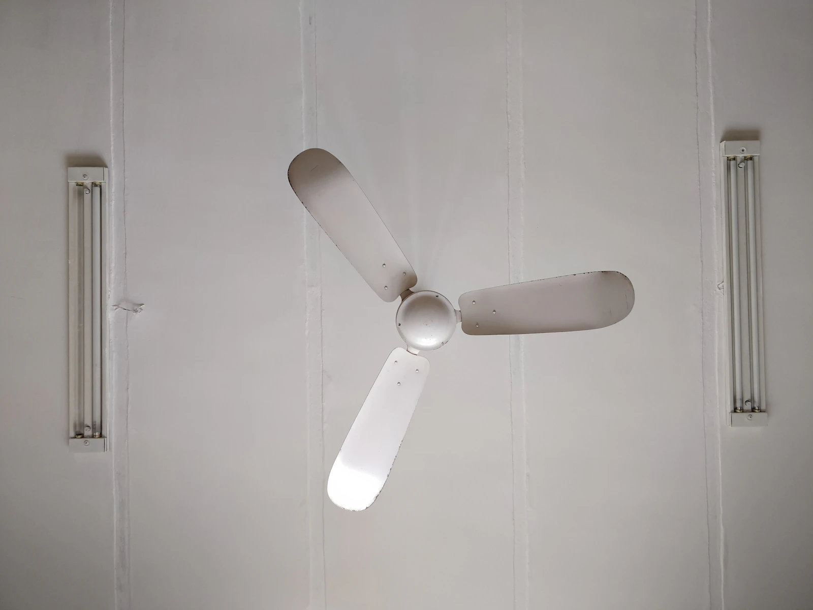 White three-blade ceiling fan mounted and wired to the ceiling