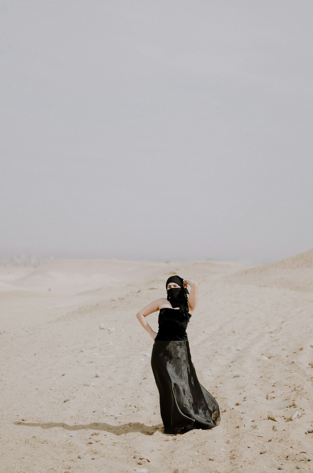 woman in black dress on desert
