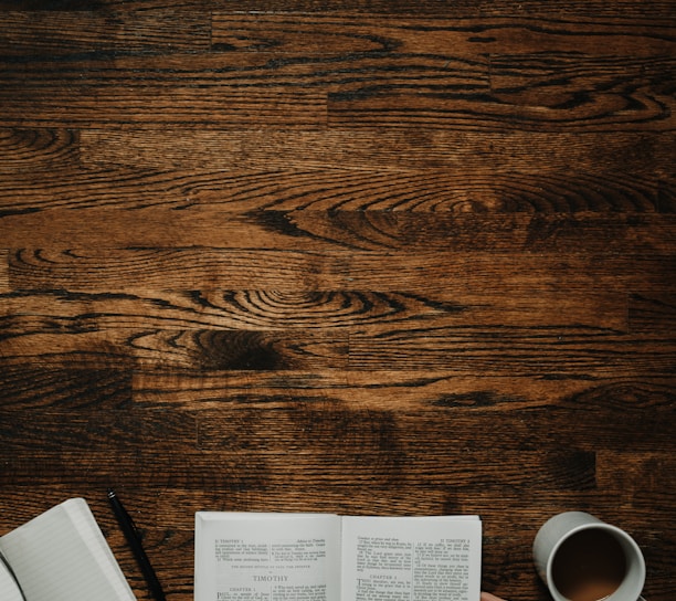 person sitting by the table opening book