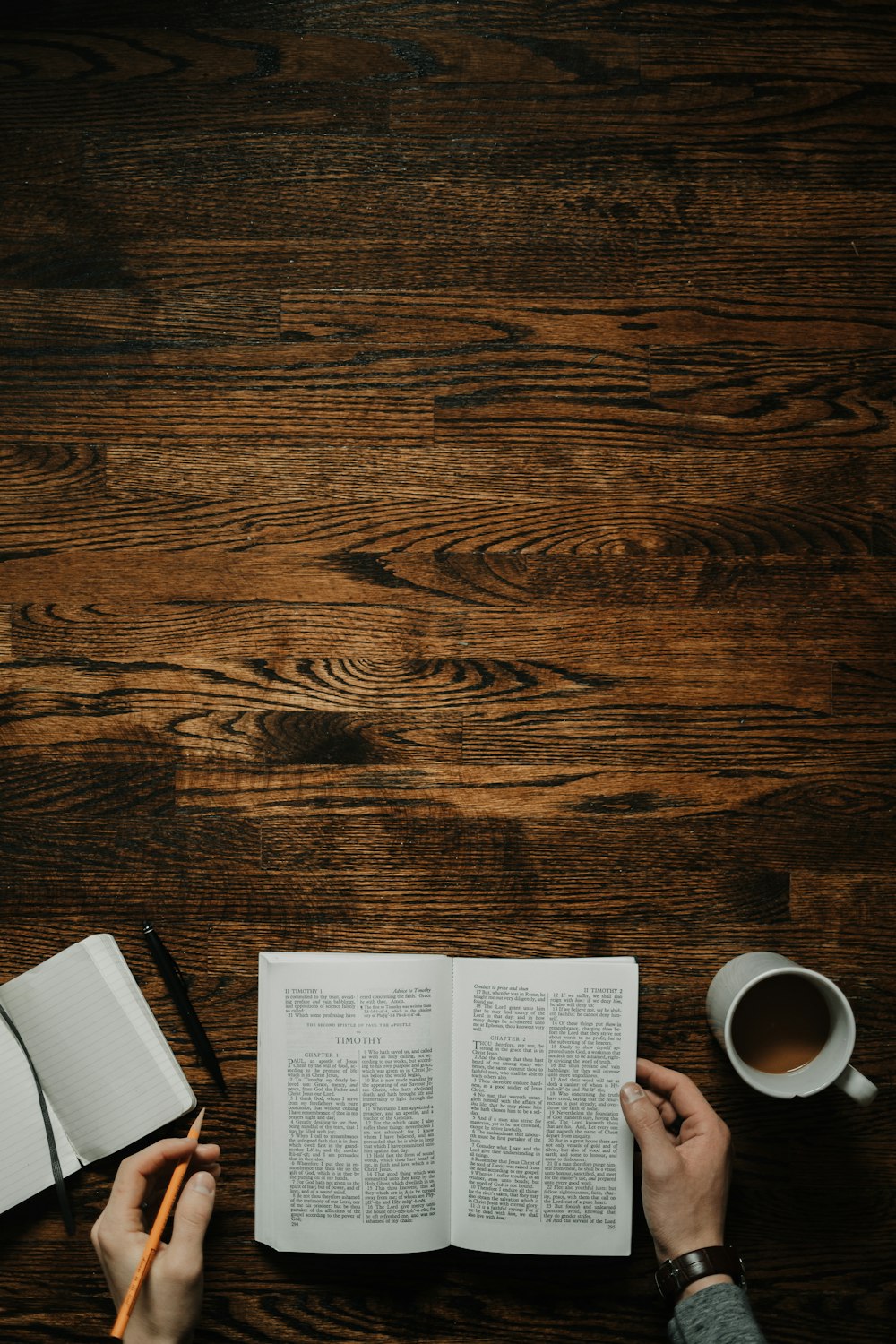 person sitting by the table opening book