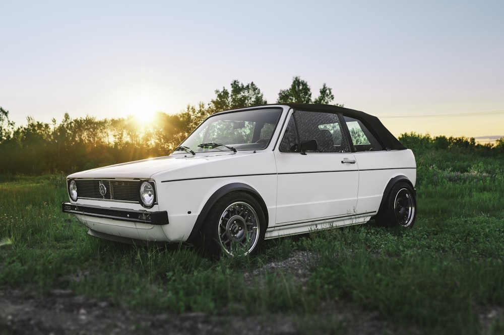 white 3-door hatchback on grass field