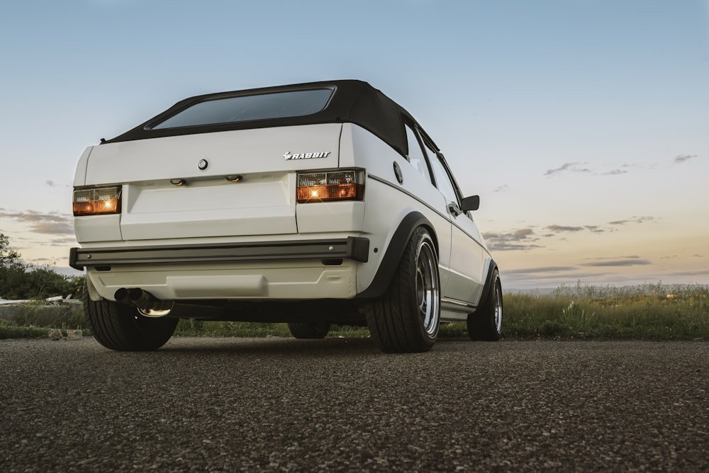 white coupe on brown road