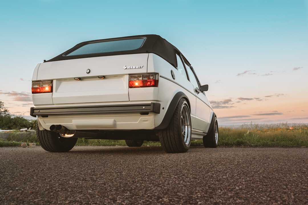 white coupe on brown road