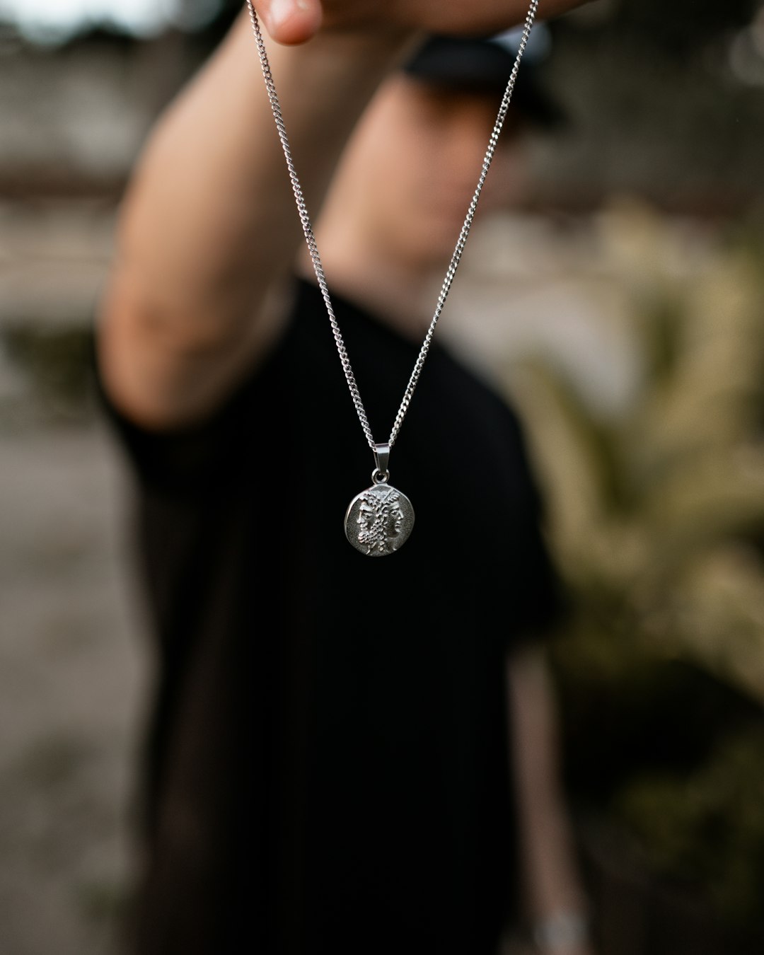 silver-colored necklace with round pendant