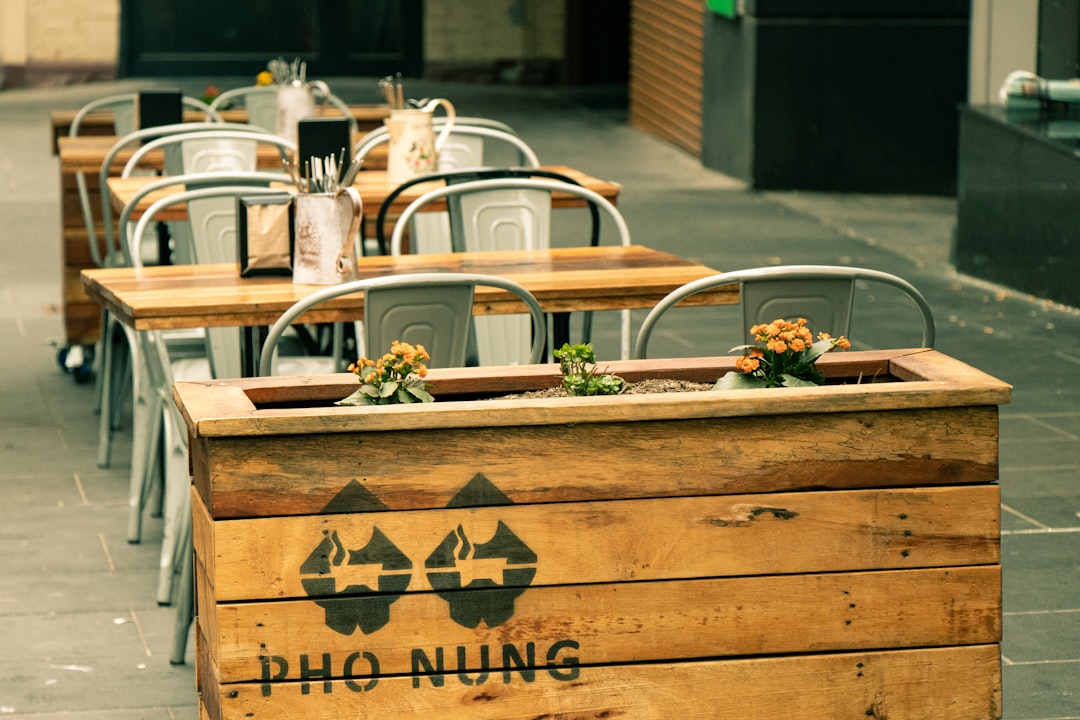 selective focus photography of brown wooden chairs beside table during daytime