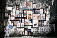 Installation process of a large wall mural sign being carefully applied by a technician.