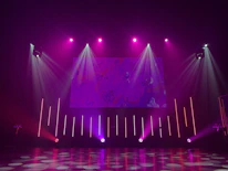 Modern event stage with purple accent lighting and sleek metal structures.
