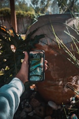 A traveler booking a cenote tour on a smartphone with a tropical cenote background