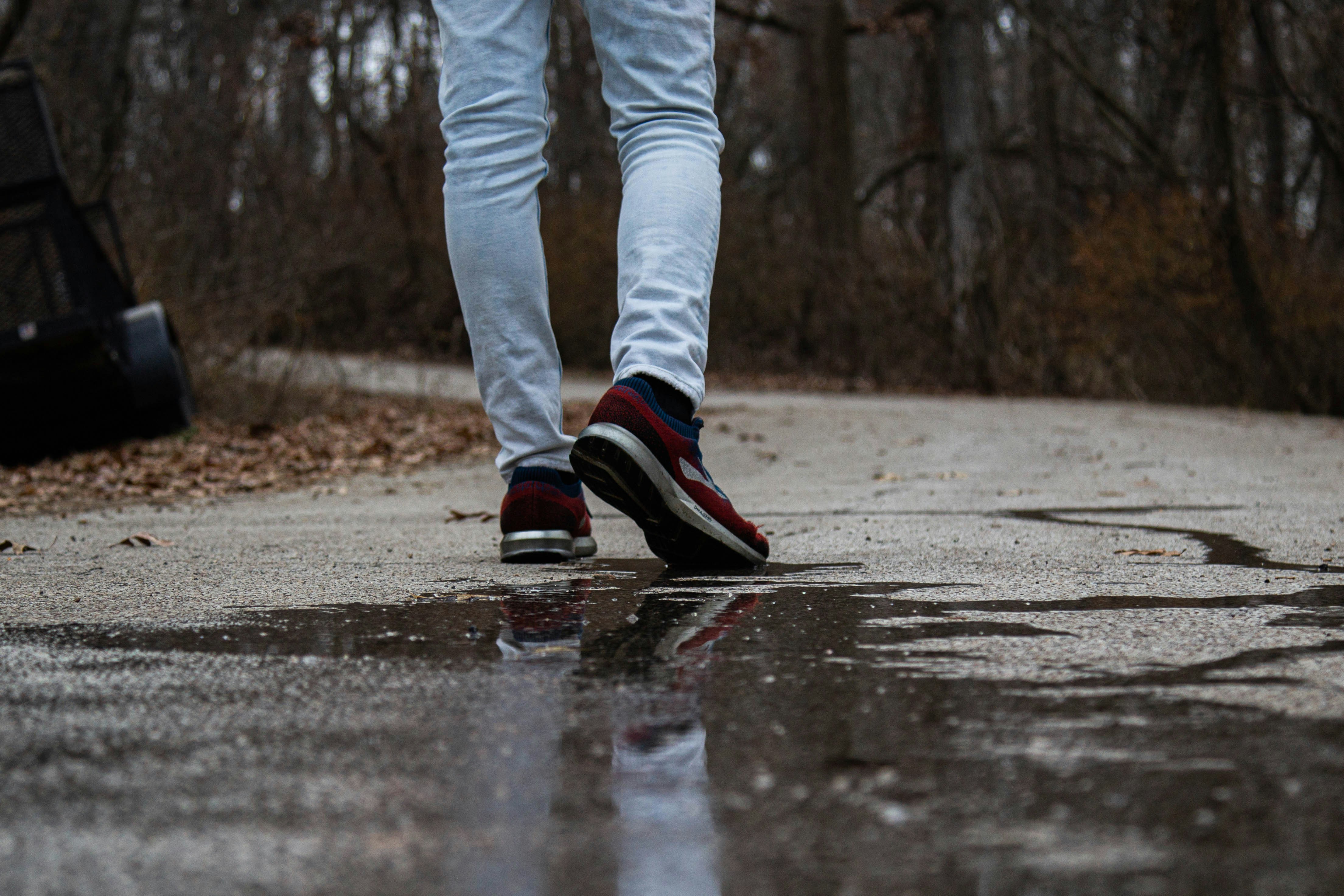 青いデニム ジーンズと黒と赤の靴を履いて立っている人の写真 Unsplashで見つける水たまりの無料写真