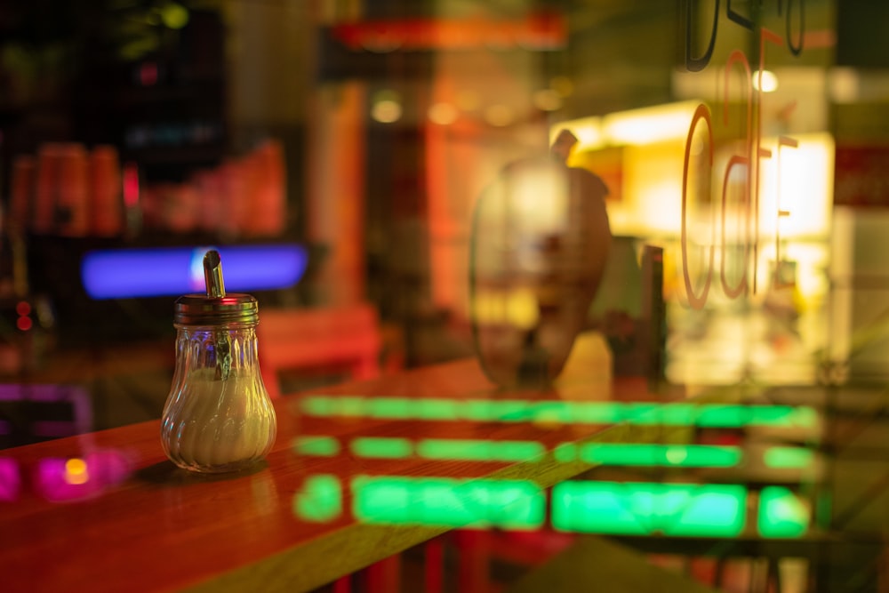 clear condiment shaker on brown table