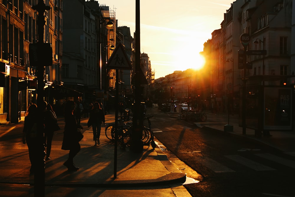 a group of people walking down a street next to tall buildings