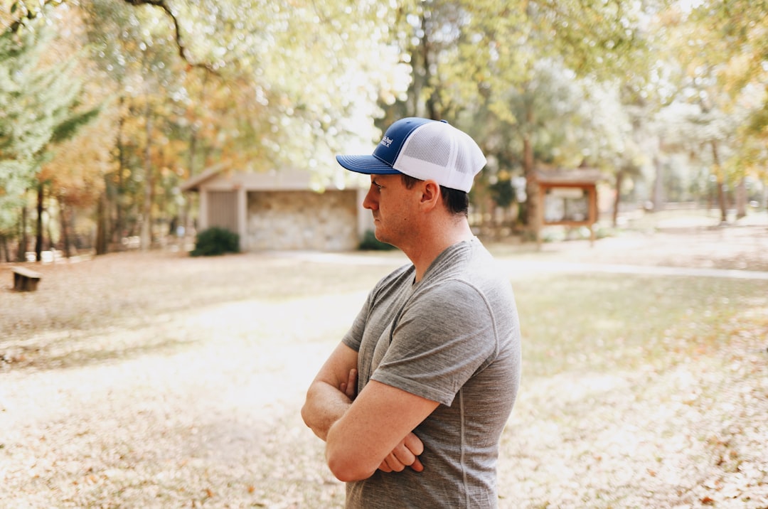 standing man crossing arms during daytime