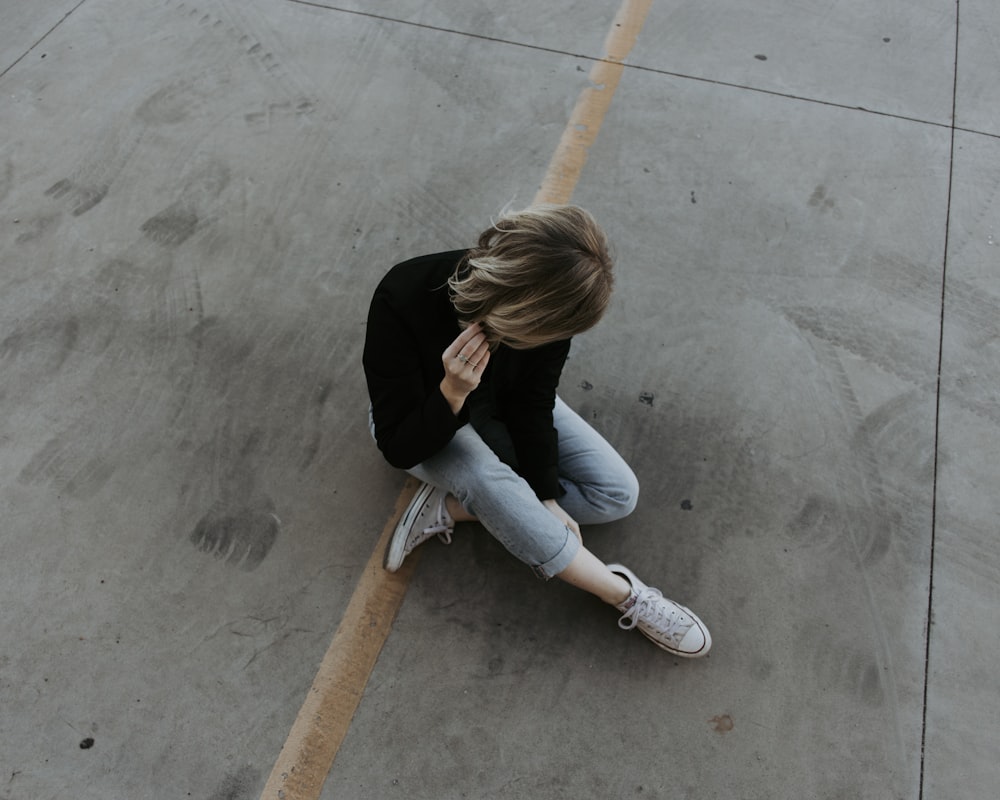 woman sitting on pavement