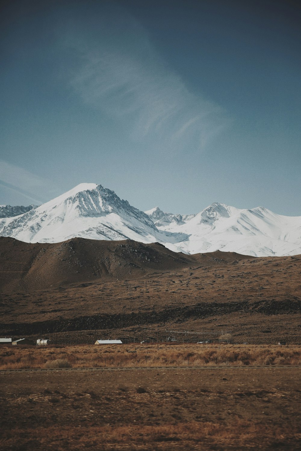 casas no campo verde que visualizam a montanha sob o céu azul e branco