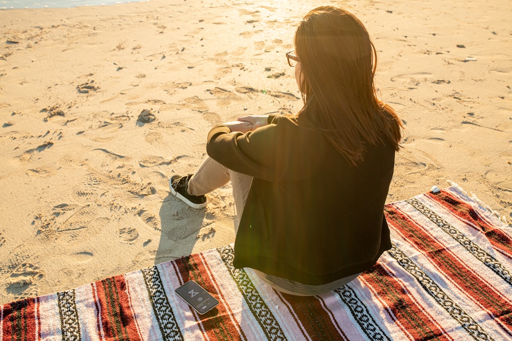 woman sitting mat on sand