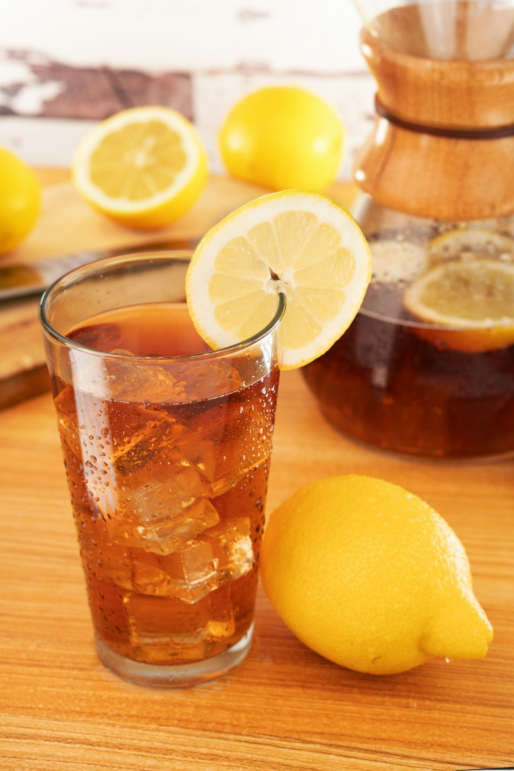 near full drinking glass with ice cubes and sliced lemon