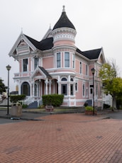 white and pink house near lampposts and road during day