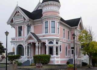 white and pink house near lampposts and road during day