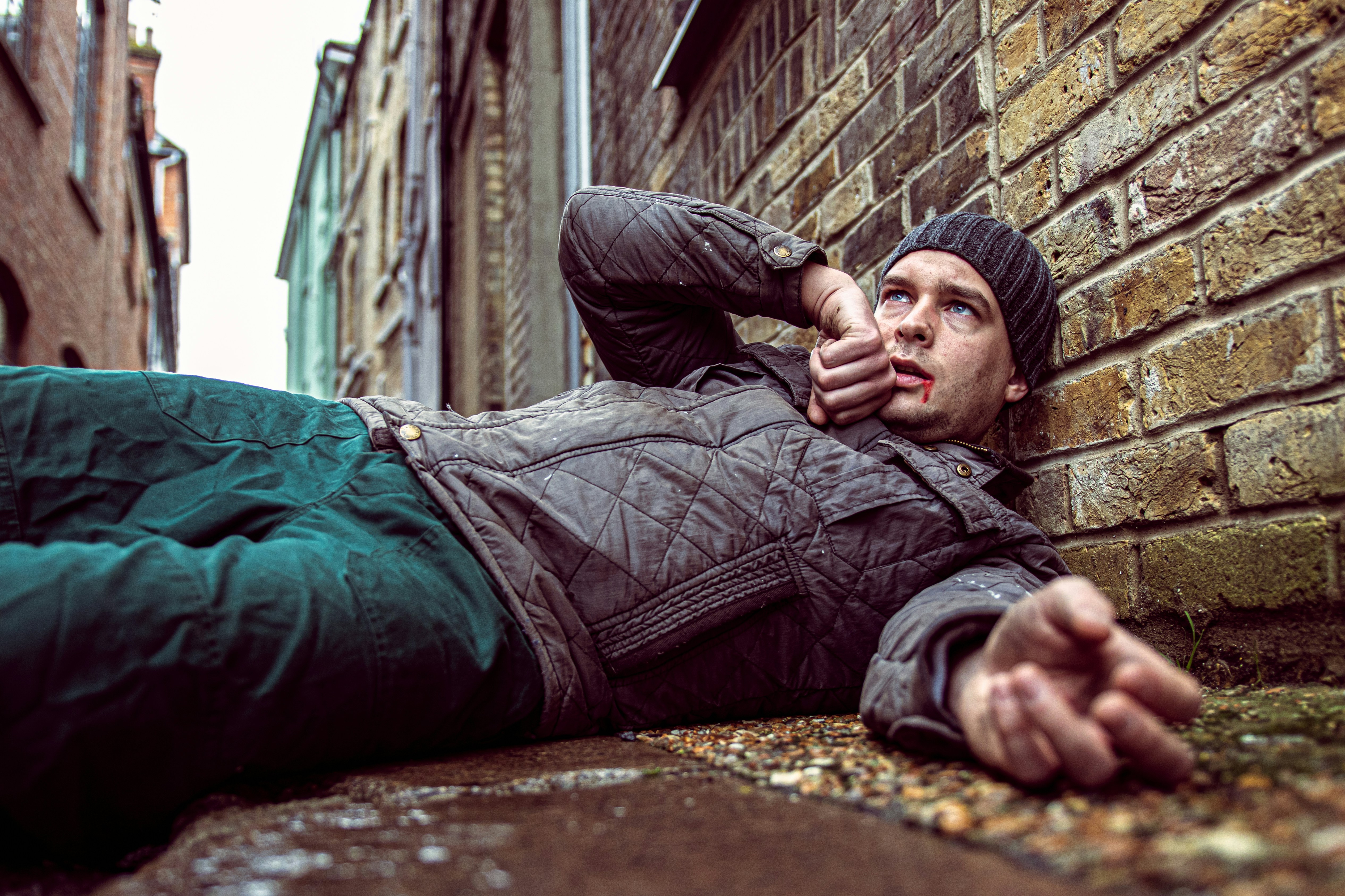 woman with blood lips lying down on the ground