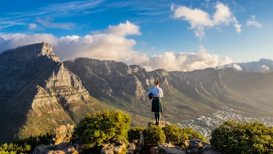 person standing on cliff during daytime in Table Mountain National Park South Africa