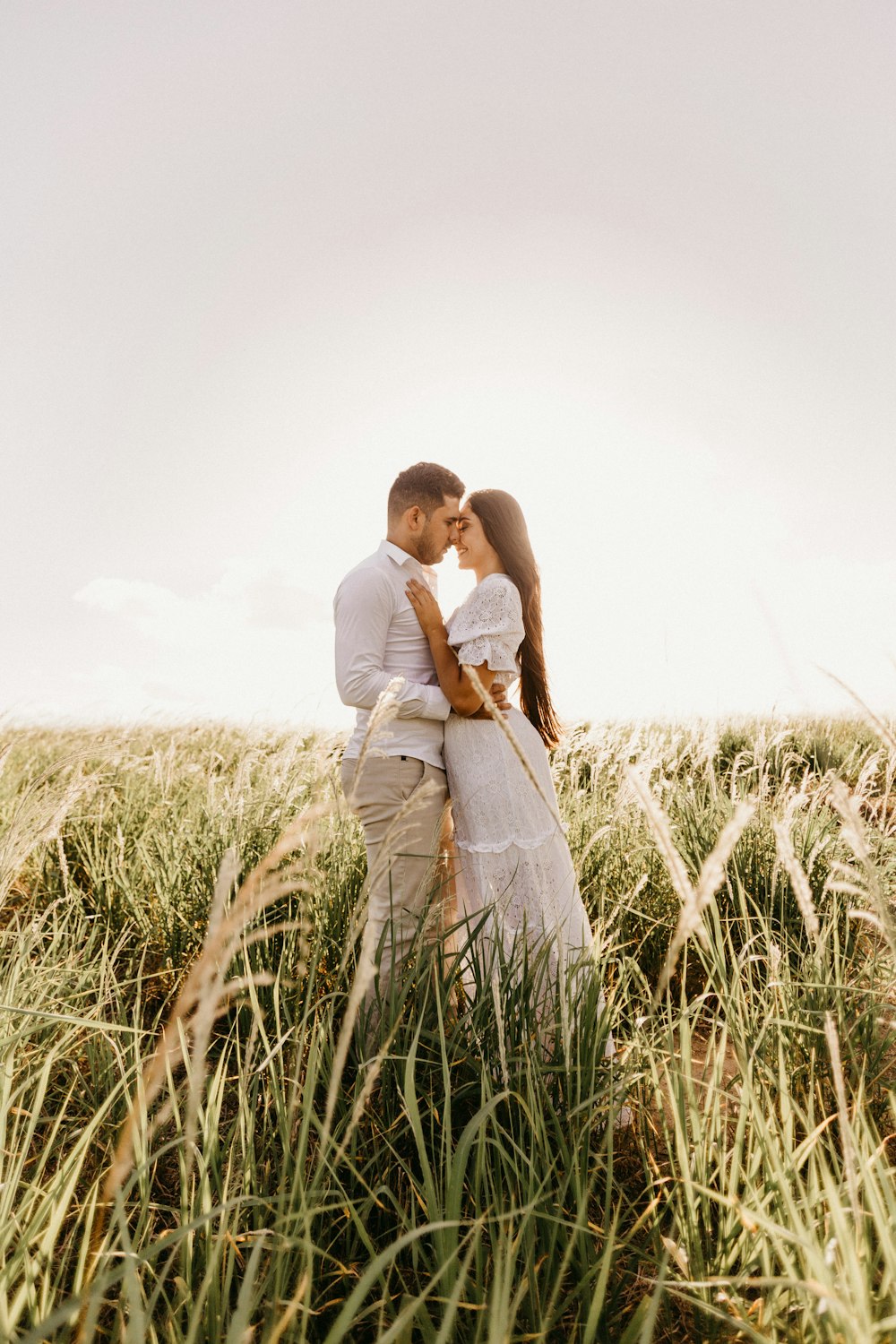 man and woman standing on grass field