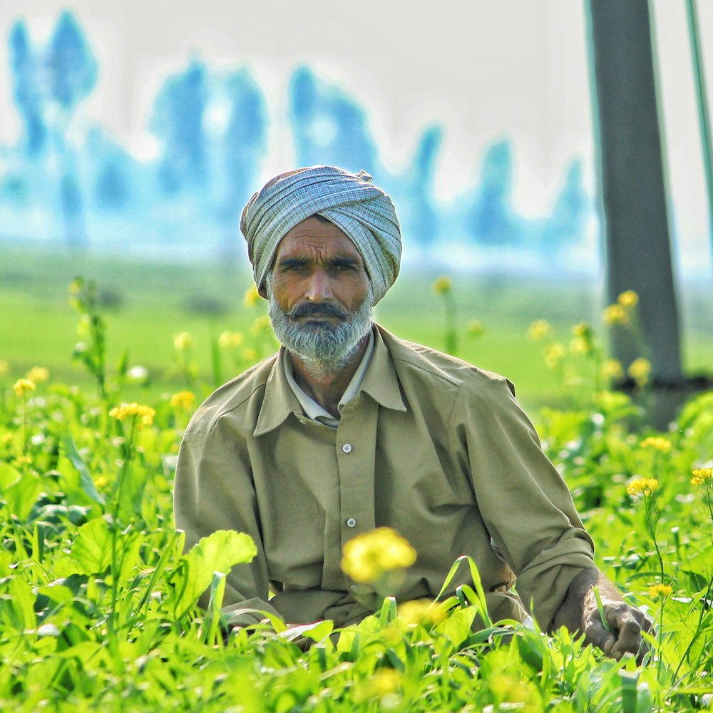 man looking at the camera beside flowers during day