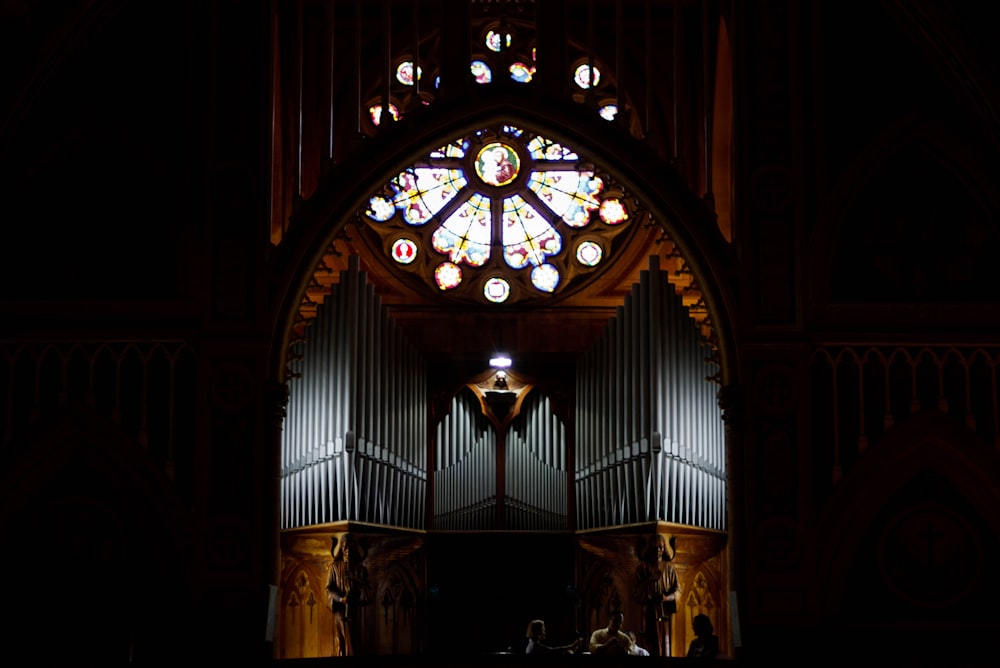 a church with a large stained glass window and pipe organ