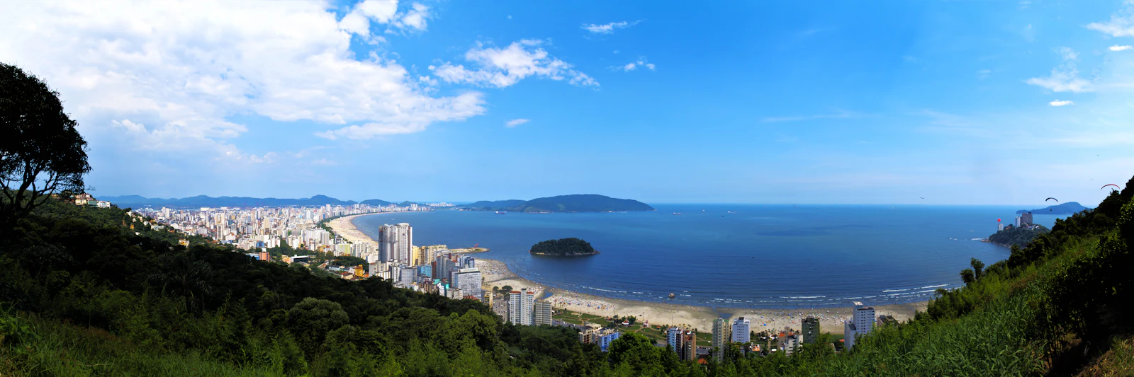 Vista do alto da baía de Santos, com os prédios da orla, a praia e o mar