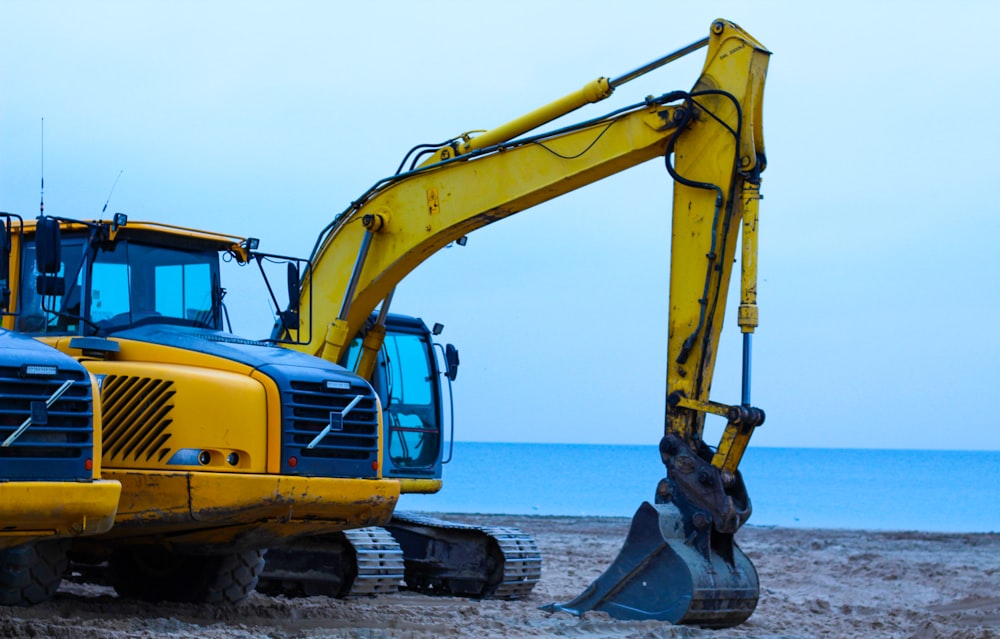 yellow excavator near body of water