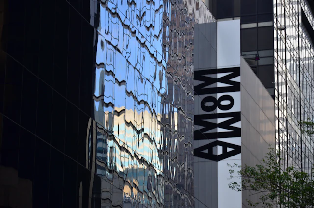 The MoMA sign mounted on the museum's glass facade in Midtown Manhattan.