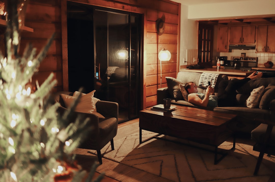 man lying on brown sofa inside room