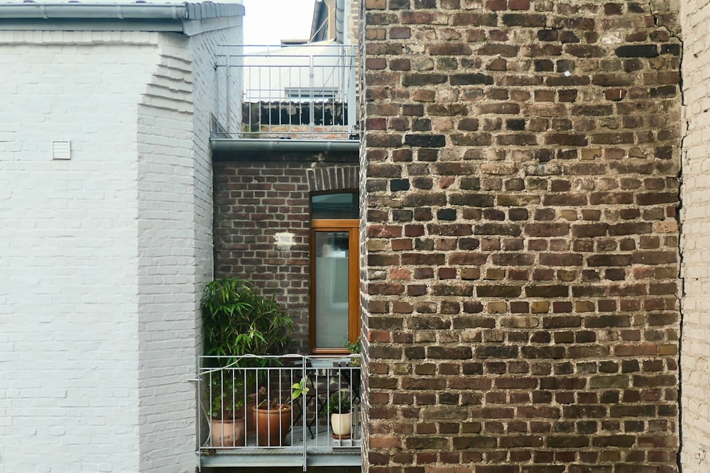 a brick building with a balcony and potted plants