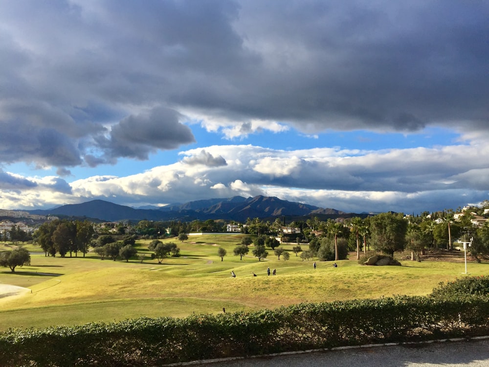 a beautiful view of a golf course with mountains in the background